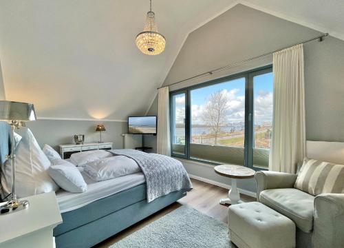 a bedroom with a bed and a large window at Ostsee - Reetdachhaus Nr 5 "Beaufort" im Strand Resort in Heiligenhafen