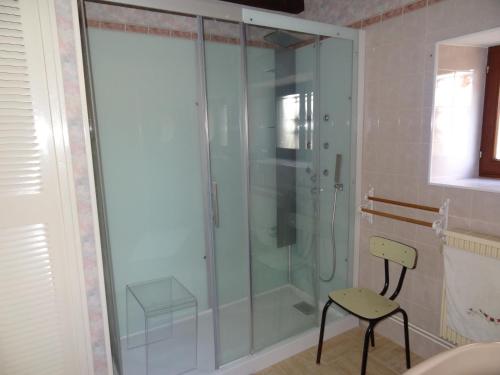 una doccia in vetro con sedia in bagno di Villa de campagne avec piscine a Beaulieu-sur-Loire