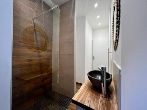 - une salle de bains avec un bol noir sur un comptoir en bois dans l'établissement Appartement cosy centre ville, à Roanne