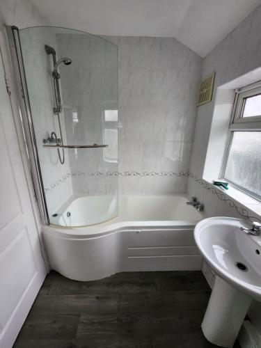 a white bathroom with a tub and a sink at Fox Hollies Shared House in Birmingham