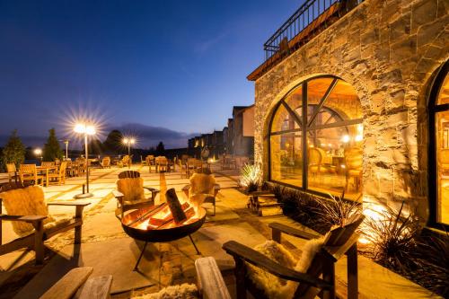 eine Terrasse mit Tischen und Stühlen und ein Gebäude in der Unterkunft Cerro Azul Hotel Fazenda in Capão Alto