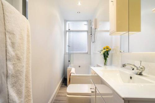 y baño blanco con lavabo y bañera. en Charming flat in quiet street in Stockbridge en Edimburgo