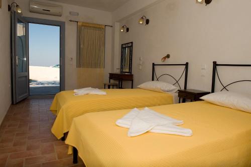 a hotel room with two beds with towels on them at Villa Murano in Fira
