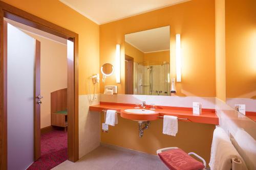 y baño con lavabo y espejo. en Vivea Hotel Bad Goisern, en Bad Goisern