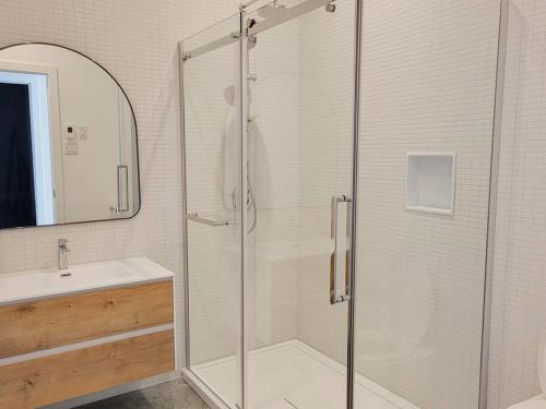 a bathroom with a glass shower and a sink at Le Ruisseau: luxurious villa in Charlevoix. in La Malbaie
