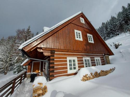 a log cabin with snow on the ground at Kajzrovka in Rokytnice nad Jizerou