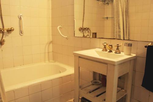 a bathroom with a sink and a bath tub at Elegancia y estilo combinados en este apartamento. in Buenos Aires
