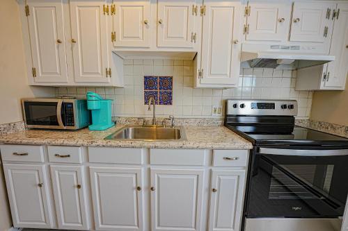 a kitchen with white cabinets and a sink and a microwave at La Posada in Milford