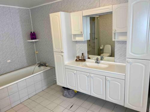 La salle de bains est pourvue d'un lavabo, d'une baignoire et d'un miroir. dans l'établissement Fjordgård Mountain Aurora View, à Fjordgård