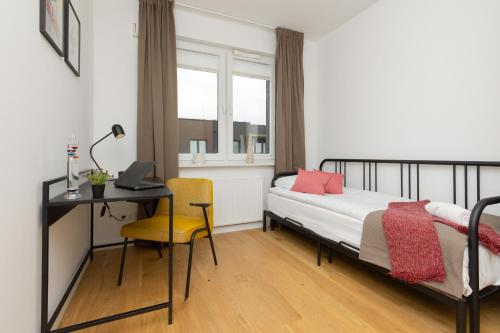 a bedroom with a bed and a desk with a laptop at Trendy & Spacious 3-room Apartament Warsaw Wilanów by Renters in Warsaw