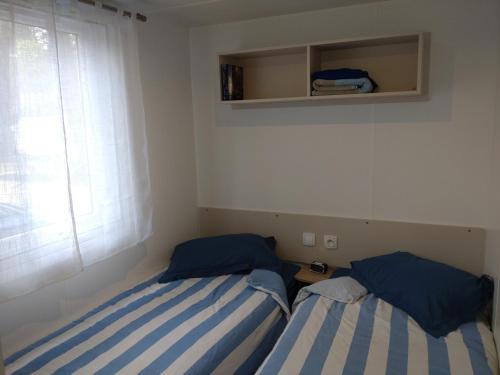 2 camas en una habitación pequeña con ventana en Prendre Un Bol D'air a Piriac sur Mer en Piriac-sur-Mer