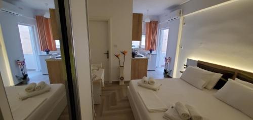 1 dormitorio con 1 cama blanca grande y cocina en The Hill Apartment, en Sarandë