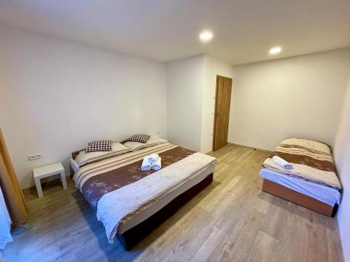 a bedroom with two beds and a wooden floor at Pension Imlauf in Vrchlabí