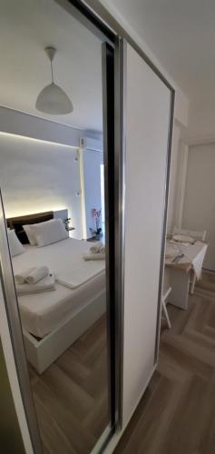 a bedroom with a bed and a mirror at The Hill Apartment in Sarandë
