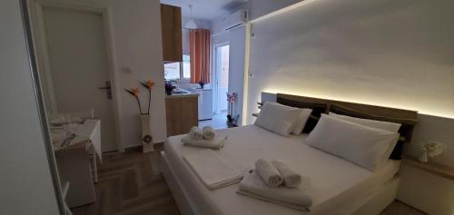 a bedroom with a large white bed with towels on it at The Hill Apartment in Sarandë