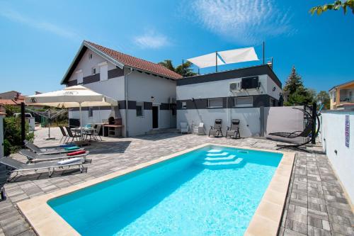 a swimming pool in front of a house at Villa Damjan in Istrien in Peroj