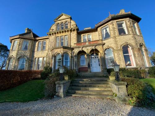 an old stone house with a staircase in front of it at Bellfield Country Suites in Masham