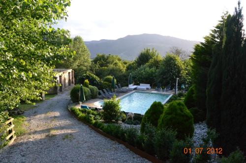a swimming pool in the middle of a garden at Palacio de Trasvilla in Escobedo