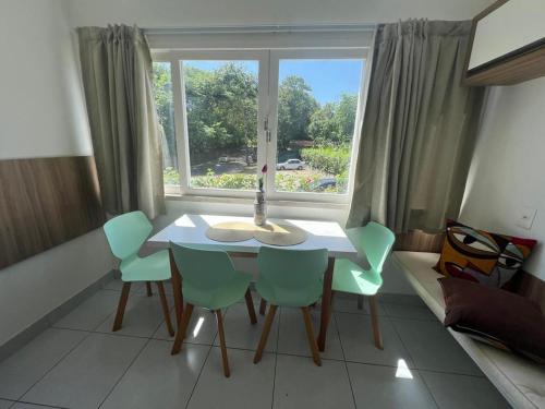 ein Tisch und Stühle in einem Zimmer mit Fenster in der Unterkunft Pipa Ubaia Residence 121 in Pipa