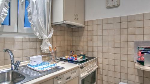 a kitchen with a sink and a stove top oven at Corfu Ionian Blue in Anemómylos
