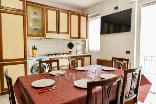 una cucina con tavolo e sedie e una sala da pranzo di 7 posti nel cuore dell'area pedonale con parcheggio a Bibione