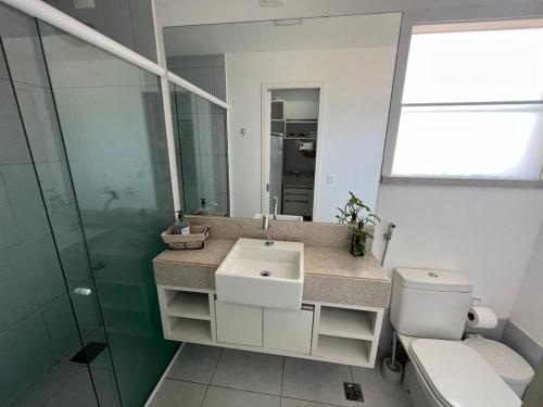 ein Badezimmer mit Waschbecken, Toilette und Spiegel in der Unterkunft Pipa Ubaia Residence 121 in Pipa