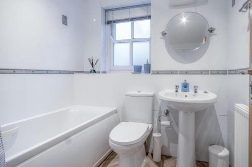ein weißes Bad mit einem WC und einem Waschbecken in der Unterkunft The Cwtch - 2 Bedroom Apartment - Tenby in Tenby