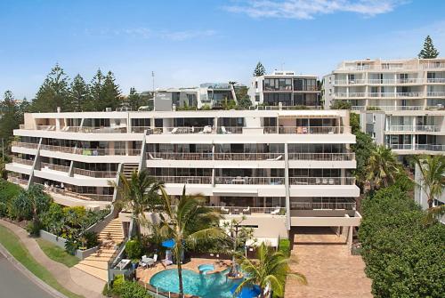 ein großes weißes Gebäude mit einem Pool davor in der Unterkunft Costa Nova Holiday Apartments in Sunshine Beach