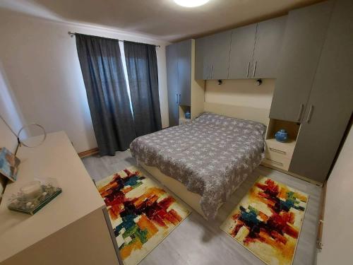 a small bedroom with a bed and two rugs at Apartament Blaj in Blaj