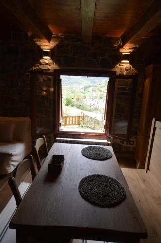 a dining room with a table and a large window at Hotel Rural El Portón de Murillo in Broto