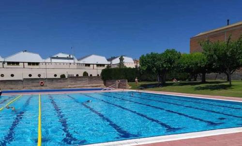 a swimming pool in front of a building at Casa Rural Namasté con SPA in Lleida