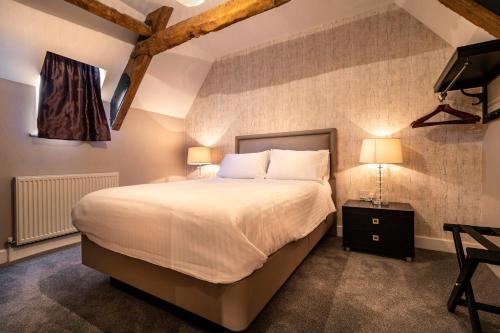 a bedroom with a large bed and a television at Swan Mews in Wells