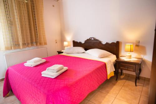a bedroom with a pink bed with towels on it at Sivas Apartments-Studios,Sigelakis with very nice view in Sívas