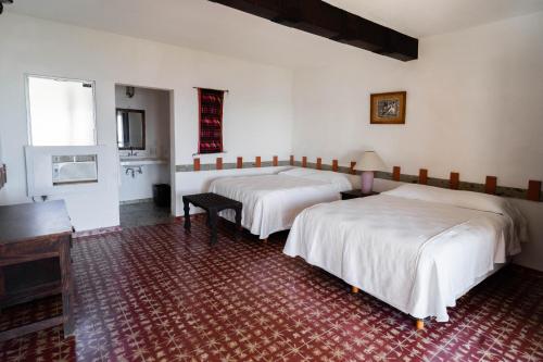 a room with two beds and a table in it at Hotel Rancho Buenavista in Los Barriles
