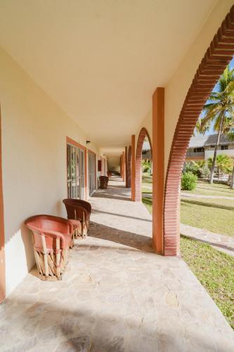 an external view of a house with chairs and a porch at Hotel Rancho Buenavista in Los Barriles