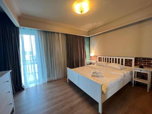 ein Schlafzimmer mit einem großen Bett und einem großen Fenster in der Unterkunft Lake View in Cluj-Napoca