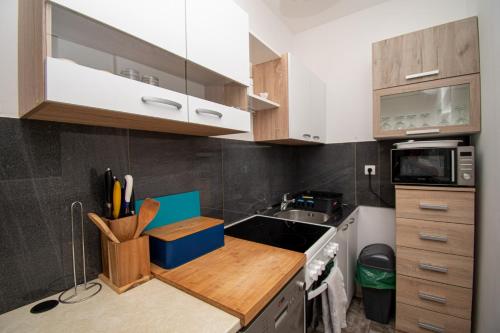 a kitchen with white cabinets and a wooden counter top at Villa Damjan in Istrien in Peroj