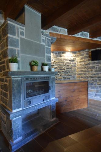 a fireplace in a room with a stone wall at Hotel Rural El Portón de Murillo in Broto