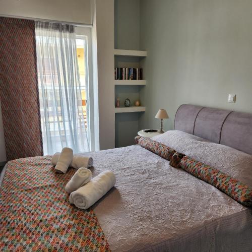 a bedroom with two towels on a bed with a window at Karystos sea side apartment in Karistos