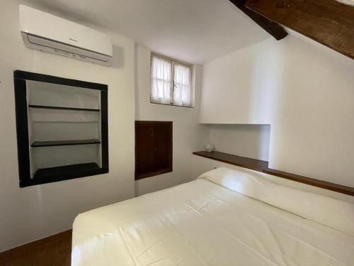 1 dormitorio con cama blanca y ventana en Nuovo Bilocale Frontemare, en Varazze