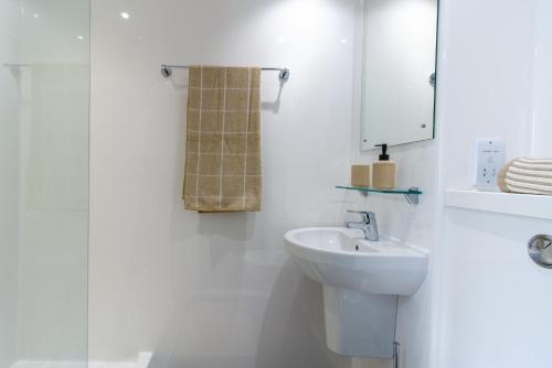 Baño blanco con lavabo y espejo en For Students Only Cosy Private Ensuites in Warwick, en Coventry