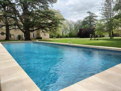 ein Swimmingpool mit blauem Wasser in einem Hof in der Unterkunft Gîte de l'Abbé 8 à 10 personnes in Lempaut