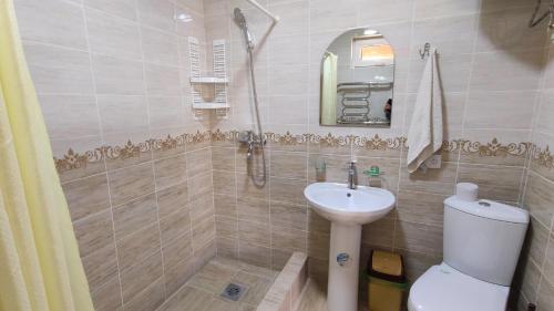 uma casa de banho com um lavatório, um WC e um chuveiro em Hotel Natalia em Kaji-Say