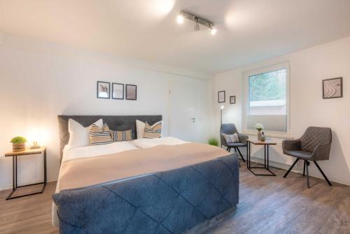 a bedroom with a large bed and a table and chairs at Gerhart-Hauptmann-Strasse 1a Ferienhaus Alex in Kolpinsee