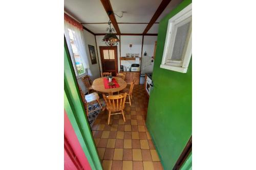 a room with green walls and a table and chairs at Ferienbungalow Waldstrasse in Ueckeritz