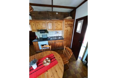 a kitchen with a wooden table and a dining room at Ferienbungalow Waldstrasse in Ueckeritz