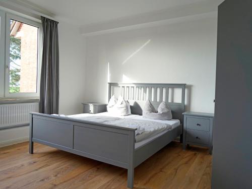 um quarto com uma cama com lençóis brancos e almofadas em Ferienhaus Strandlust em Baltrum