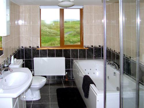 łazienka z umywalką, wanną i toaletą w obiekcie No 3 Atlantic View Spanish Point w mieście Spanish Point