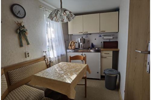 a small kitchen with a table and a dining room at Ferienwohnung Hasenlodde in Loddin