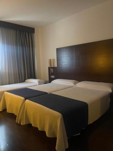 a hotel room with two beds in a room at Complejo Leo 24H in Monesterio